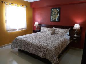 科苏梅尔PRIME VILLAGE Cozumel的一间卧室设有一张带红色墙壁的大床