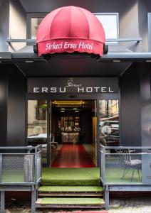 伊斯坦布尔Sirkeci Ersu Hotel & SPA的一条街道出口酒店的入口,带红伞