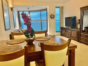 海法Luxurious Beach apartment的一间带桌椅和电视的用餐室