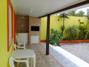 圣加布里埃尔Pousada Cabral的配有桌椅和黄色墙壁的客房