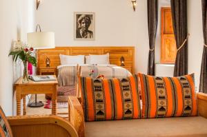 马拉喀什里亚德苏塔尼旅馆的酒店客房配有一张床和一张桌子,床上铺有羊绒