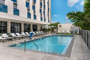 迈阿密Comfort Inn & Suites Miami International Airport的一个带躺椅的游泳池和一间酒店
