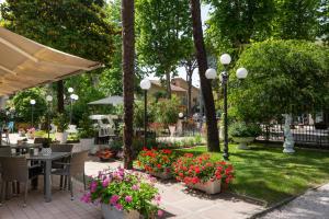 切尔维亚Hotel Verde Luna的庭院配有桌椅和鲜花