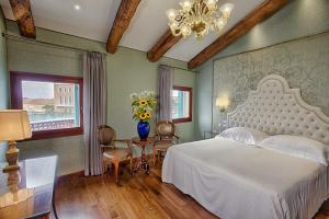 威尼斯Hotel Santa Chiara的卧室配有白色的床和花瓶
