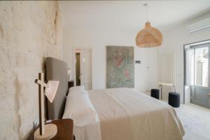 阿尔贝罗贝洛Trulli Resort Aia Piccola的白色的卧室,配有一张带横跨床的床铺