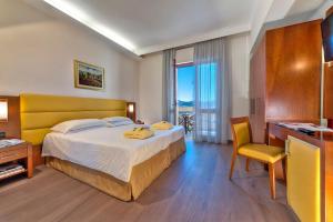 蒙特格罗托泰梅安东尼亚诺温泉酒店的配有一张床、一张书桌和一扇窗户的酒店客房