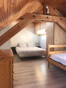 维拉尔-德朗Appartement centre village的一间卧室设有两张床和木制天花板