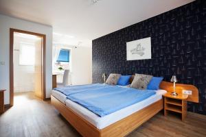 诺伊韦克岛Hotel Hus Achtern Diek的一间卧室设有一张床和黑色的墙壁