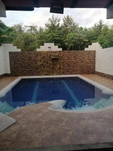 拉多拉达Hotel Brisas Del Magdalena的后院的游泳池,有砖墙