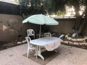 甘亚夫内הבית בגן的一张桌子、两把椅子和一把伞