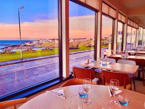 布什米尔斯湾景酒店的一间设有桌椅的海景餐厅