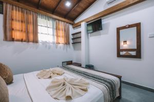达瓦拉维Jungle Paradise的一间卧室配有一张床,上面有两条毛巾