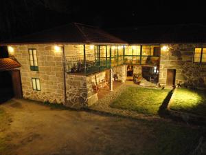 Rairiz de Veiga卡萨瑞克托拉康达旅馆的夜晚有灯的石头房子