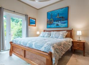 圣佩德罗Belizean Cove Estates Luxury Beachfront Villa的卧室配有一张床,墙上挂有绘画作品