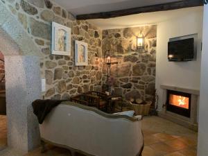 皮同伊斯-达斯-朱尼亚斯卡萨坎普费雷拉度假屋的客厅设有带壁炉的石墙