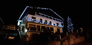 拉格利塔兹阿尔卑斯鲜花酒店的屋顶上晚上有圣诞灯的房子