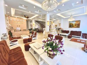 大叻郁金香酒店的一间设有椅子和鲜花桌子的等候室