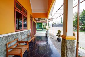 梭罗Hotel BIP Tawangmangu的一个带桌子和长凳的建筑的门廊