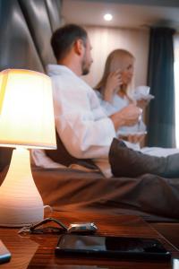 安加尔斯克子午线酒店的坐在床上的男人和女人,拿着灯