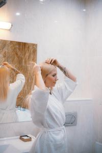 安加尔斯克子午线酒店的女人在浴室里干头发