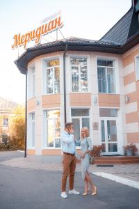 安加尔斯克子午线酒店的站在建筑物前面的男人和女人