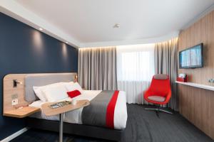爱丁堡爱丁堡-利斯海滨智选假日酒店的酒店客房,配有一张床和一张红色椅子