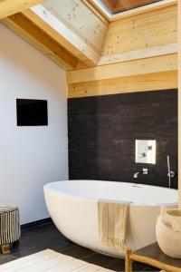 大博尔南沙丽特拉维格根埃特Spa酒店的带浴缸的浴室和木制天花板