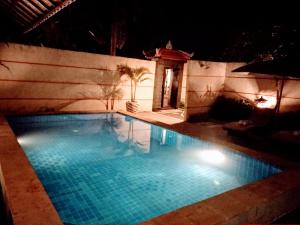 苏卡瓦提Kartika Dahayu Private Pool Villas的夜间游泳池,灯光照亮