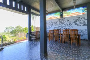 珀尼达岛Hostel Bukit Sangcure的用餐室配有木椅和涂鸦墙