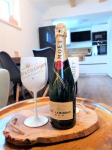 霍尔马拉帕WOOD HOME - Luxury Mountain Apartment的一瓶香槟和一张桌子上的葡萄酒杯