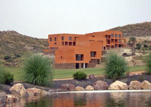 维拉Preciosa Casa de diseño Valle del Este Golf Resort ideal para familias的前方有湖泊的房子的 ⁇ 染