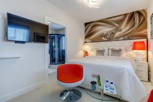 阿姆斯特丹B&B Modern Times的一间卧室配有一张大床和一张红色椅子