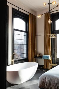 GoirleStella Suites Boutique Hotel的窗户前带白色浴缸的浴室