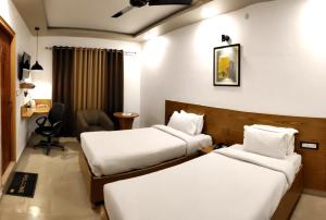 瑞诗凯诗Green Hills Cottage Rishikesh的酒店客房配有两张床和一张书桌