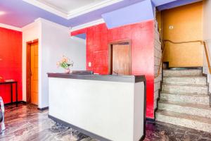 韦斯帕夏诺Ouro Hotel的大堂设有红色和白色的墙壁和楼梯