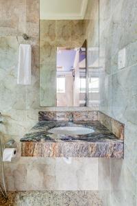 韦斯帕夏诺Ouro Hotel的一间带水槽和镜子的浴室