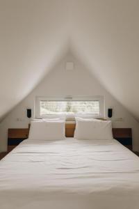 科巴里德Nebesa Chalets的卧室配有白色的床和窗户