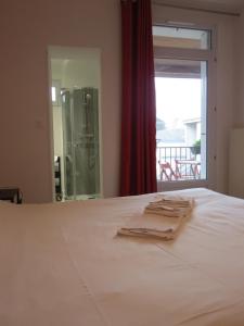 圣阿韦尔坦费桑酒店的卧室配有白色的床、窗户和玻璃门