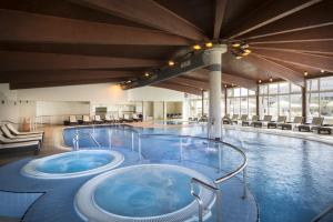 巴斯卡Corinthia Baška Sunny Hotel的一个带两个热水浴缸的大型游泳池