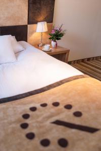 弗罗茨瓦夫精品酒店 的一张带白色毯子的床,上面有熊猫脸