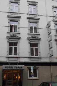 美因河畔法兰克福Hotel Topas Frankfurt City的白色的建筑,旁边标有标志