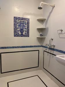 斋浦尔Jaipur Haveli的浴室设有水槽和蓝白色瓷砖墙。