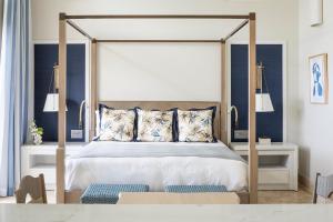 圣约翰斯Jumby Bay Island - an Oetker Collection Hotel的一间卧室配有一张天蓬床和蓝色的墙壁