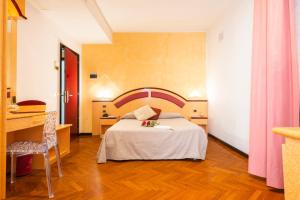 圣贝内代托-德尔特龙托Hotel Regent - In pieno Centro的酒店客房配有一张床铺、一张桌子和一张书桌。