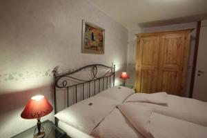 Yvorne奥伯格可姆尔德拉克尼酒店的一间卧室配有一张带白色床单和红灯的床。