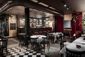 米兰Speronari Suites的一间带桌椅的餐厅和一间酒吧