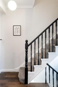 伦敦HSA - Shoreditch的房屋内的楼梯,有白色的墙壁和黑色的栏杆