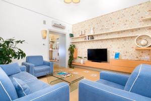 圣安吉洛Unconventional Sorrento Coast的客厅配有蓝色椅子和电视