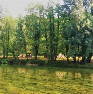 NetretićRobinson camp Kupa - Juratovićki brig的享有树木和帐篷的河流美景