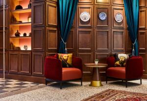 威尼斯Hotel Indigo Venice - Sant'Elena, an IHG Hotel的木墙客房的两张椅子和一张桌子